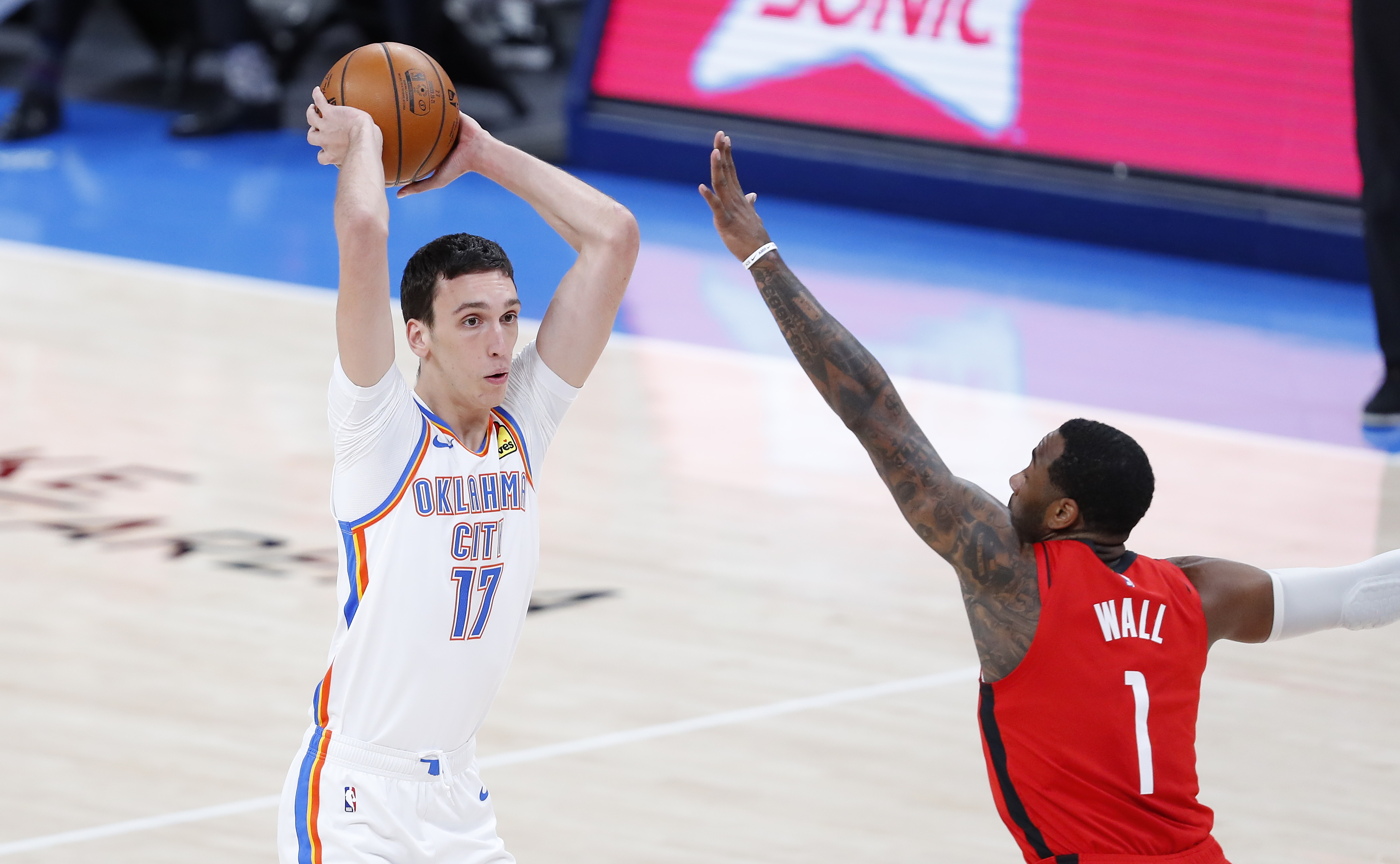 Feb 1, 2021; Oklahoma City, Oklahoma, USA; Oklahoma City Thunder forward Aleksej Pokusevski (17) passes the ball as Houston Rockets guard John Wall (1) defends during the first half at Chesapeake Energy Arena.