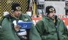 Jordan Love and Aaron Rodgers sit together on the sideline while Love reads a tablet.