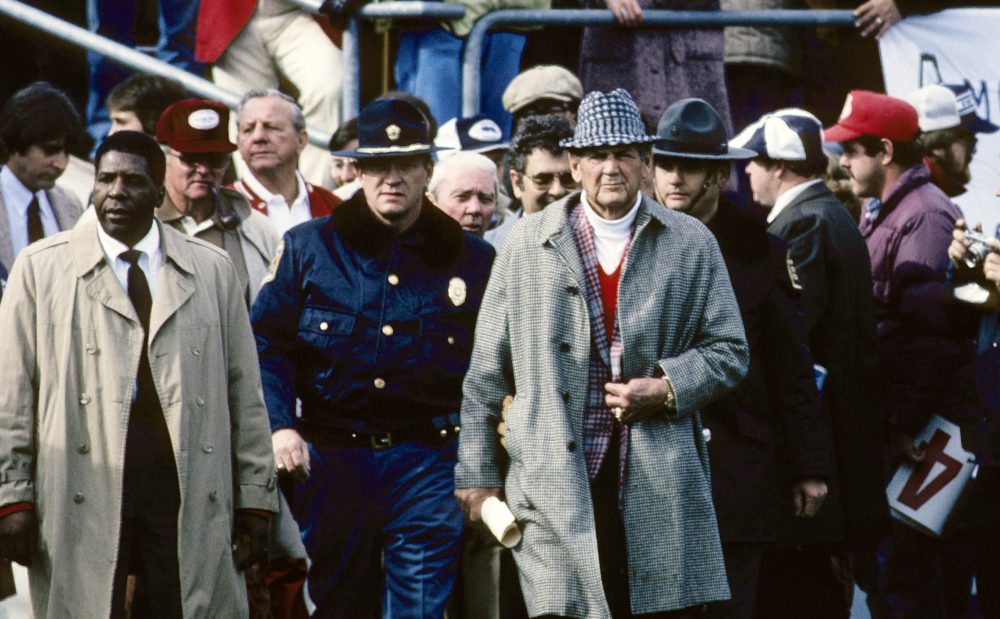 Alabama football coach Bear Bryant walks onto the field at Penn State's packed Beaver Stadium.