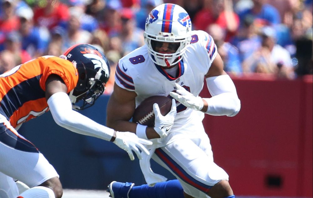 OJ Howard runs upfield as a Broncos defender leans in to tackle him.