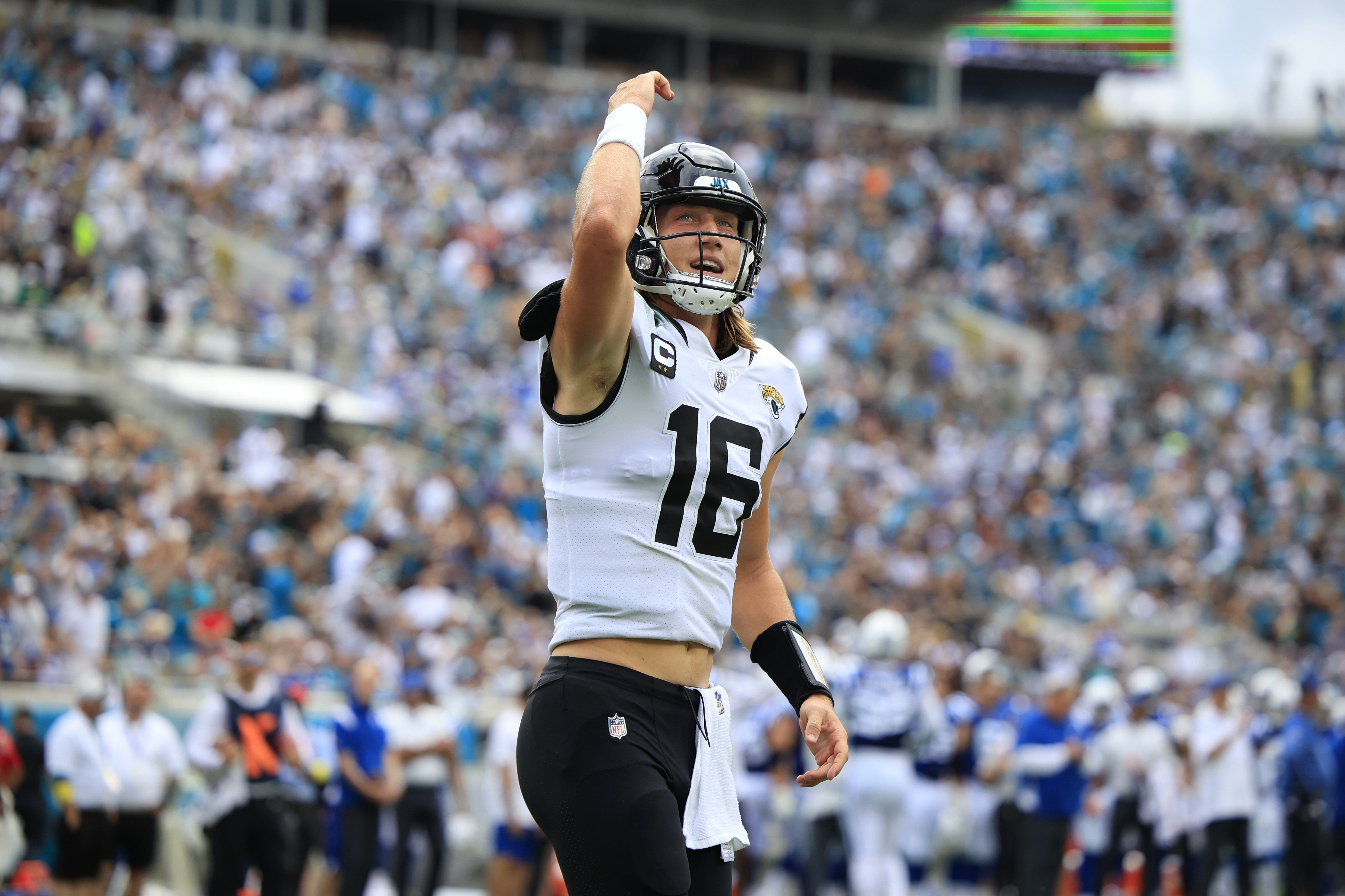 Trevor Lawrence raises his right arm in celebration.
