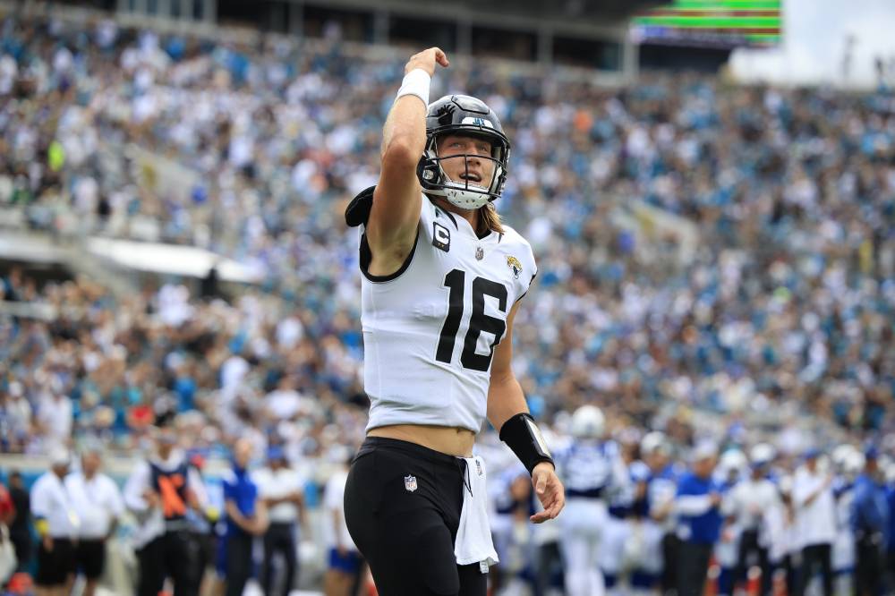 Trevor Lawrence raises his right arm in celebration.