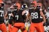 Three Browns players celebrate as Jacoby Brissett, middle flexes in triumph.