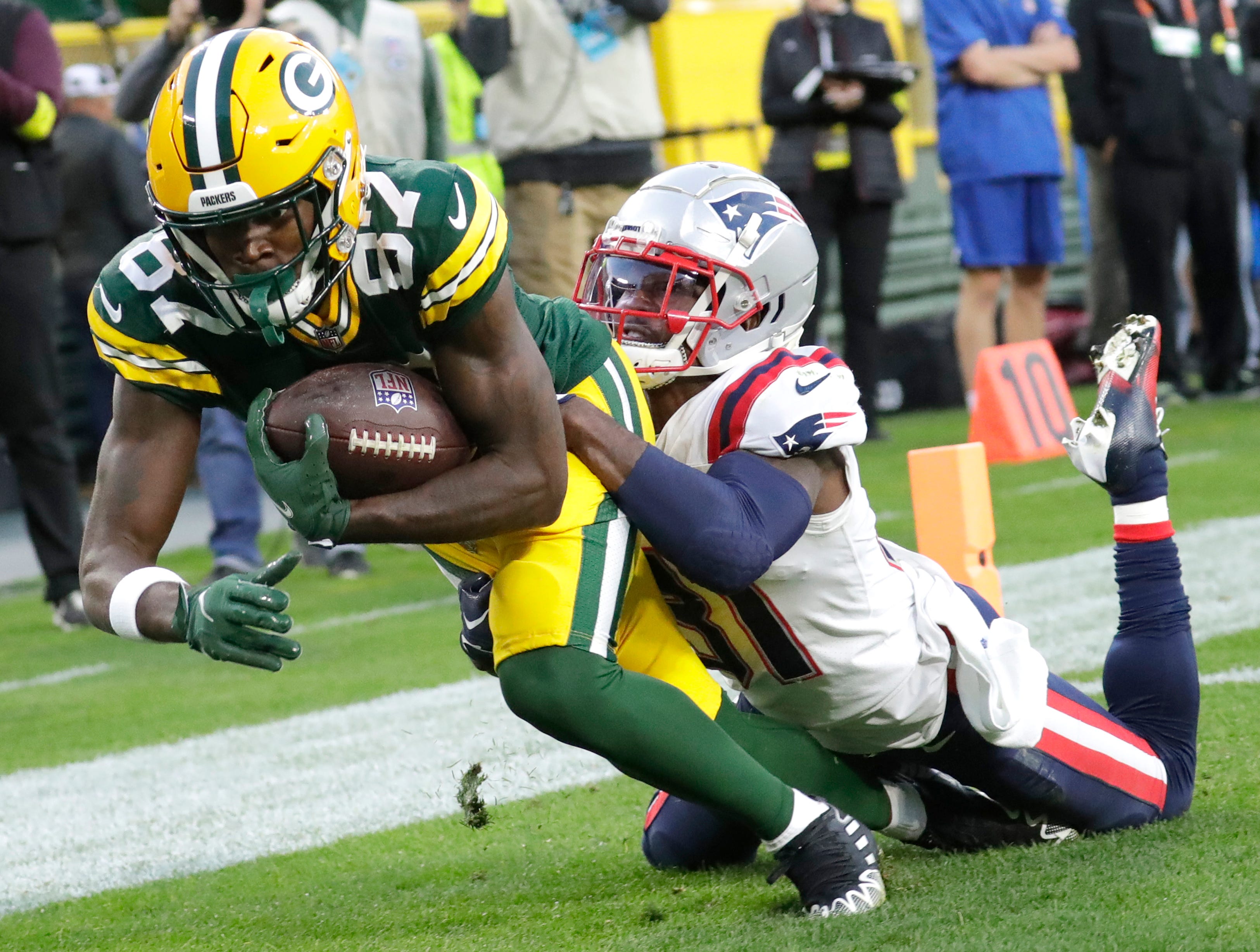 Green Bay Packers wide receiver Romeo Doubs (87) tries to score a touchdown against New England Patriots cornerback Jonathan Jones (31) in the fourth quarter during their football game Sunday, October 2, at Lambeau Field in Green Bay, Wis. The pass was incomplete because Doubs could not maintain control of the ball.