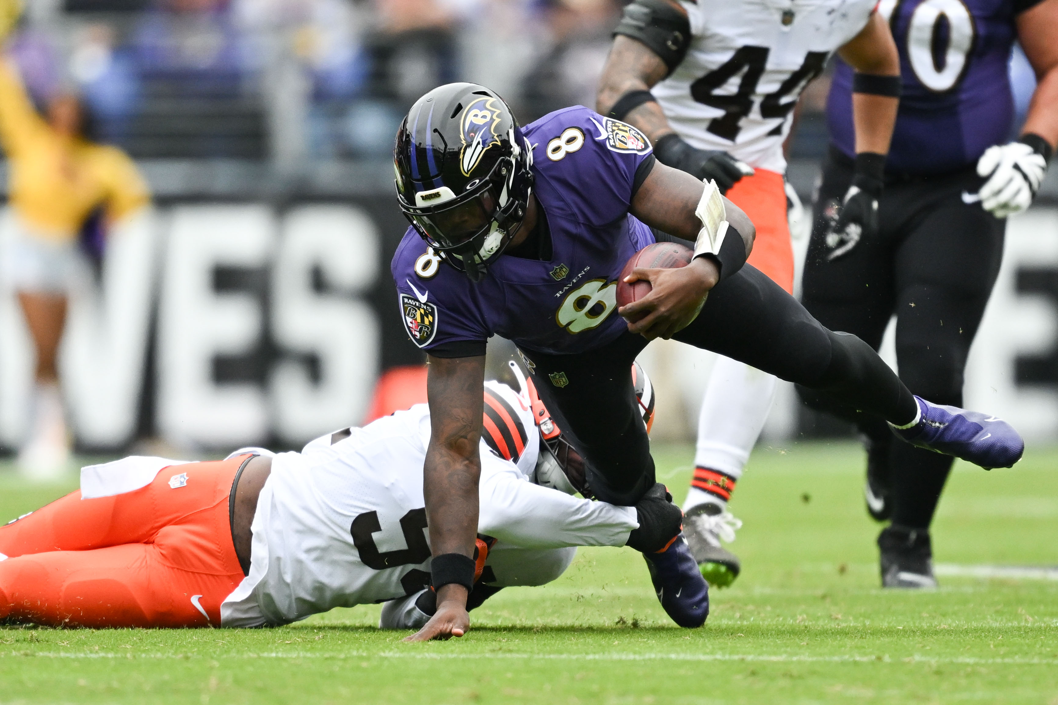 Oct 23, 2022; Baltimore, Maryland, USA; Baltimore Ravens quarterback Lamar Jackson (8) scrambles away from Cleveland Browns defensive end Myles Garrett (95) during the first half at M&T Bank Stadium. 