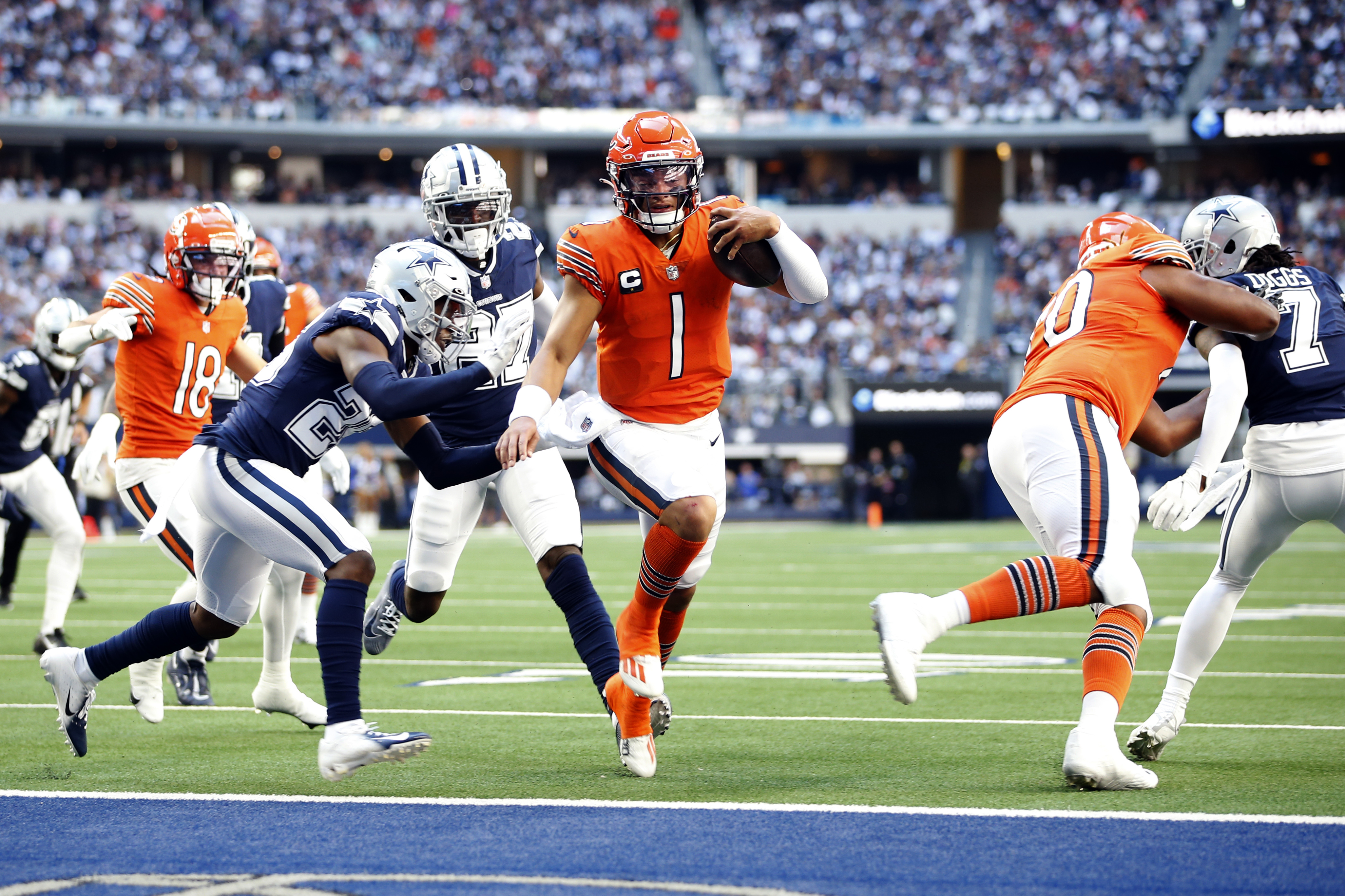 Oct 30, 2022; Arlington, Texas, USA; Chicago Bears quarterback Justin Fields (1) scores a touchdown in the second quarter against Dallas Cowboys cornerback DaRon Bland (26) at AT&T Stadium. 