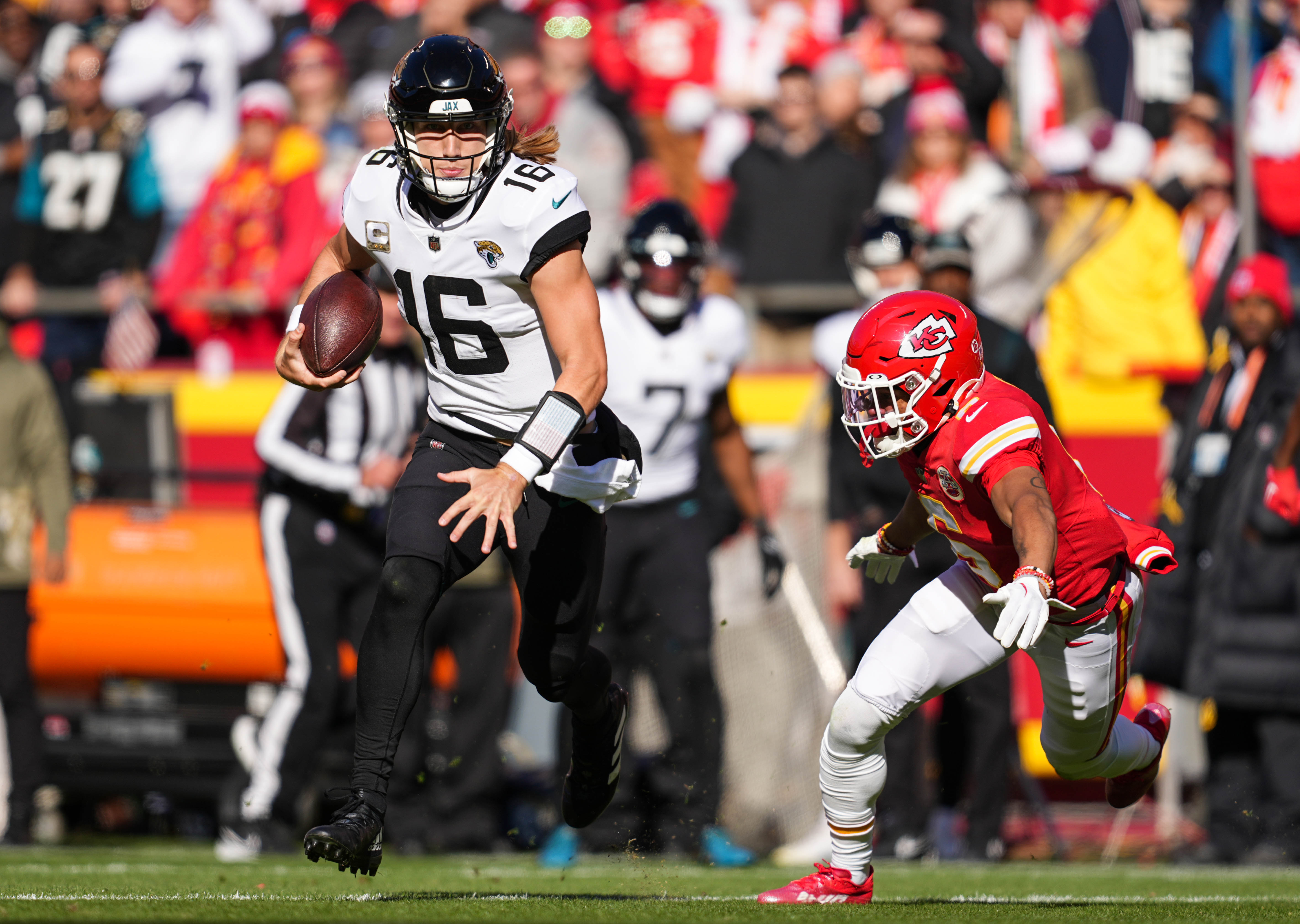Nov 13, 2022; Kansas City, Missouri, USA; Jacksonville Jaguars quarterback Trevor Lawrence (16) runs the ball against Kansas City Chiefs safety Bryan Cook (6) during the first half at GEHA Field at Arrowhead Stadium. 