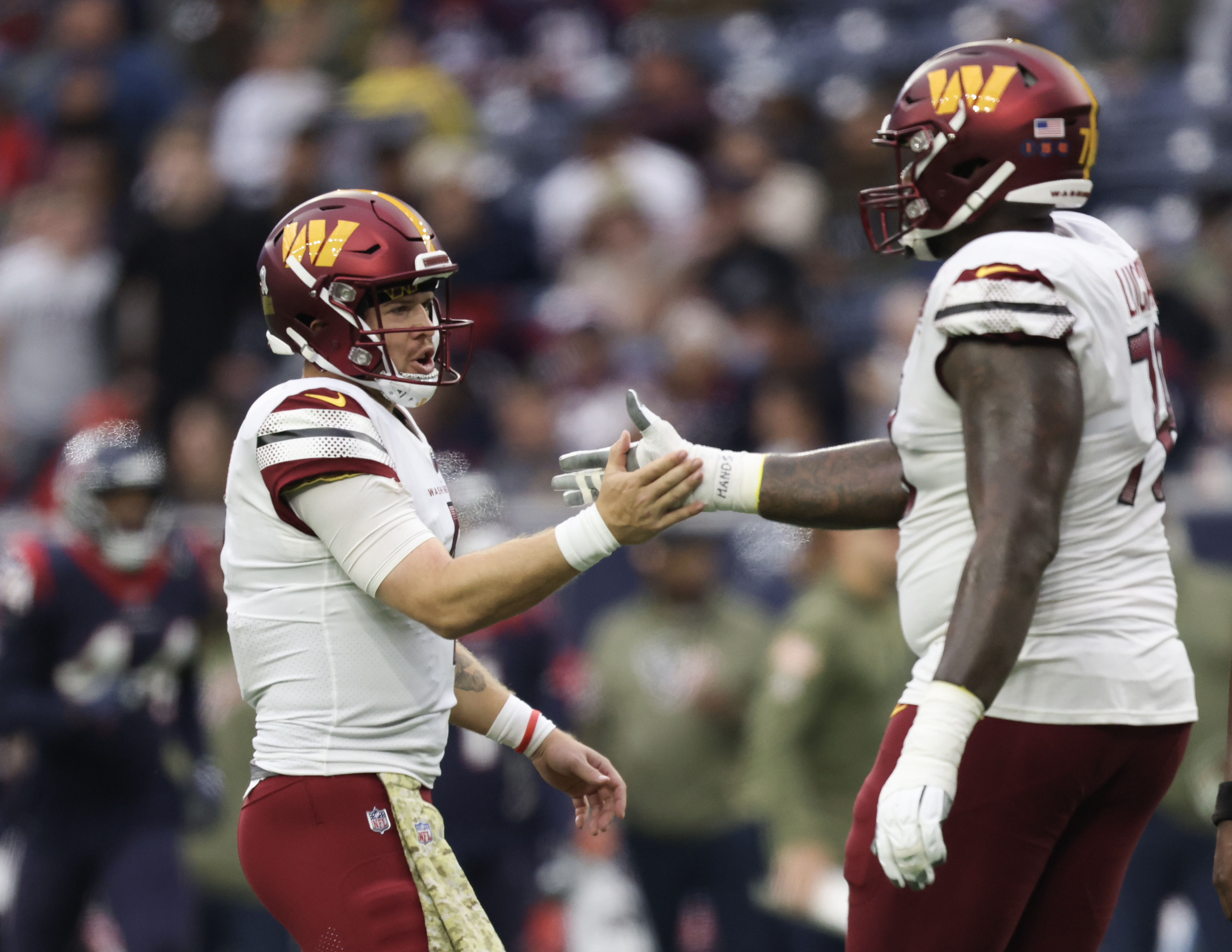 Nov 20, 2022; Houston, Texas, USA; Washington Commanders offensive tackle Cornelius Lucas (78) and quarterback Taylor Heinicke (4) celebrate wide receiver Curtis Samuel (10) (not pictured) touchdown against the Houston Texans in the second quarter at NRG Stadium.