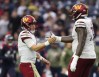 Nov 20, 2022; Houston, Texas, USA; Washington Commanders offensive tackle Cornelius Lucas (78) and quarterback Taylor Heinicke (4) celebrate wide receiver Curtis Samuel (10) (not pictured) touchdown against the Houston Texans in the second quarter at NRG Stadium.