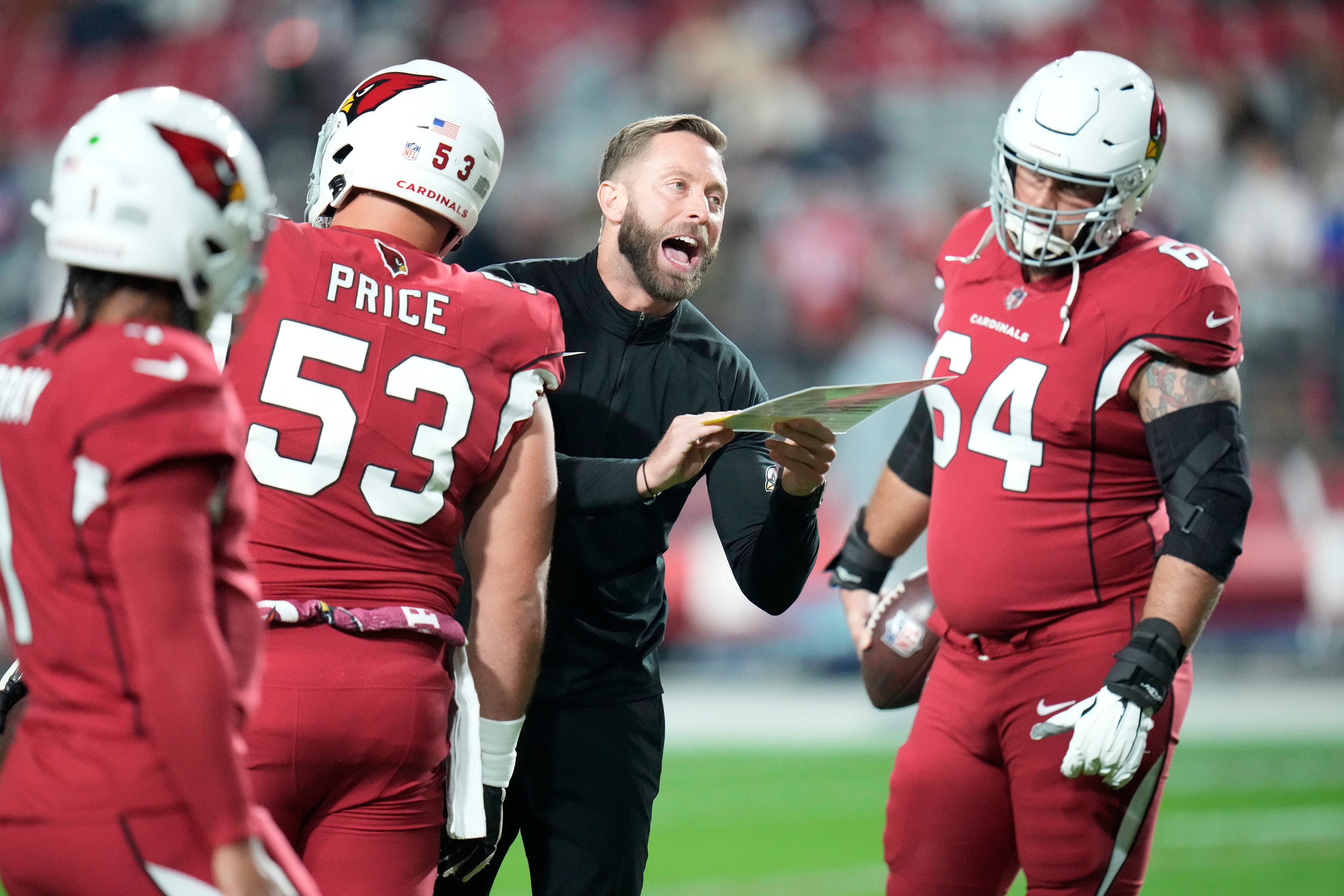 Dec 12, 2022; Glendale, Ariz., USA; Arizona Cardinals head coach Kliff Kingsbury leads his players in pre-game warm ups before playing against the New England Patriots at State Farm Stadium. 