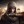 Assassin's Creed Mirage is a shorter stealth game, Ubisoft says: A man wearing a beige hood is holding his left arm horizontally in front of him. In his hand is a blade, and behind him is an outline of domes and majestic buildings