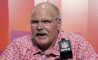 kansas city chiefs coach andy reid sitting with red shirt in front of microphone