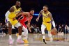 D'Angelo Russell dribbles the ball past C.J. McCollum as LeBron James looks on.