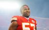 Orlando Brown Jr. smiles during a Chiefs-Rams game in 2022 with a spotlight in the background.