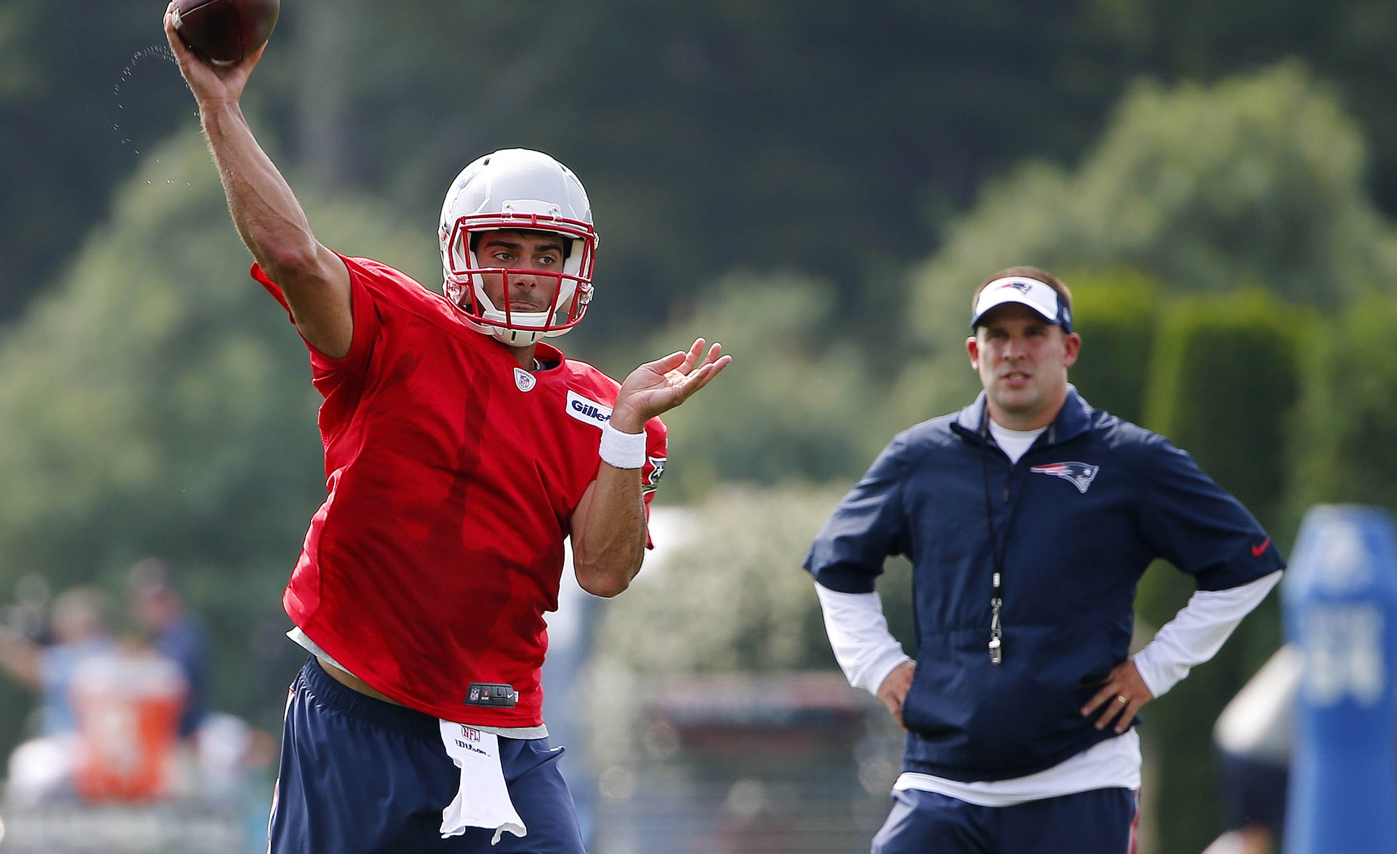 Jimmy Garoppolo throws a practice pass for the Patriots as offensive coordinator Josh McDaniels looks on.