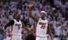 Jimmy Butler has his hand up, while Bam Adebayo also reacts behind him.
