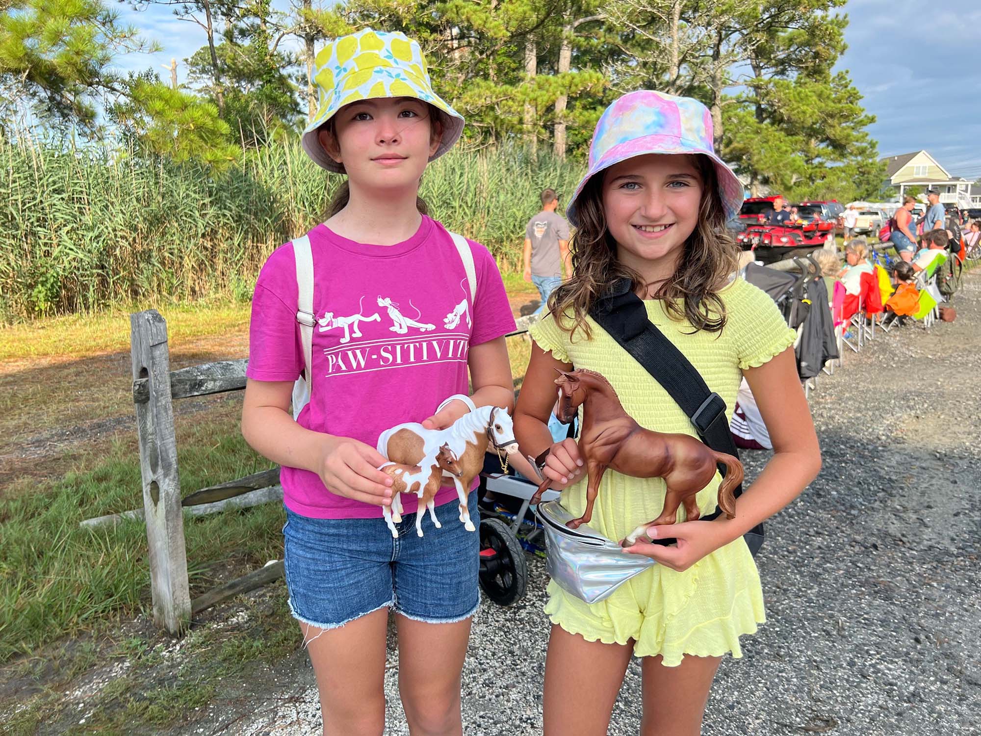 Two girls holding horse figurines.
