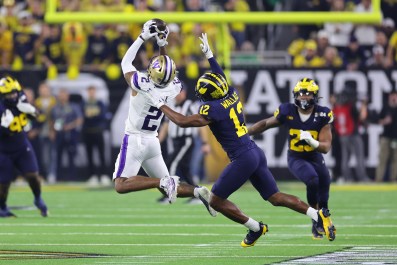 Ja'Lynn Polk #2 of the Washington Huskies catches a pass against Josh Wallace #12 of the Michigan Wolverines in the first half during the 2024 CFP National Championship game at NRG Stadium on January 08, 2024 in Houston, Texas