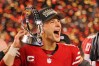 San Francisco 49ers quarterback Brock Purdy (13) holds the George Halas Trophy while after winning the NFC Championship football game against the Detroit Lions at Levi's Stadium