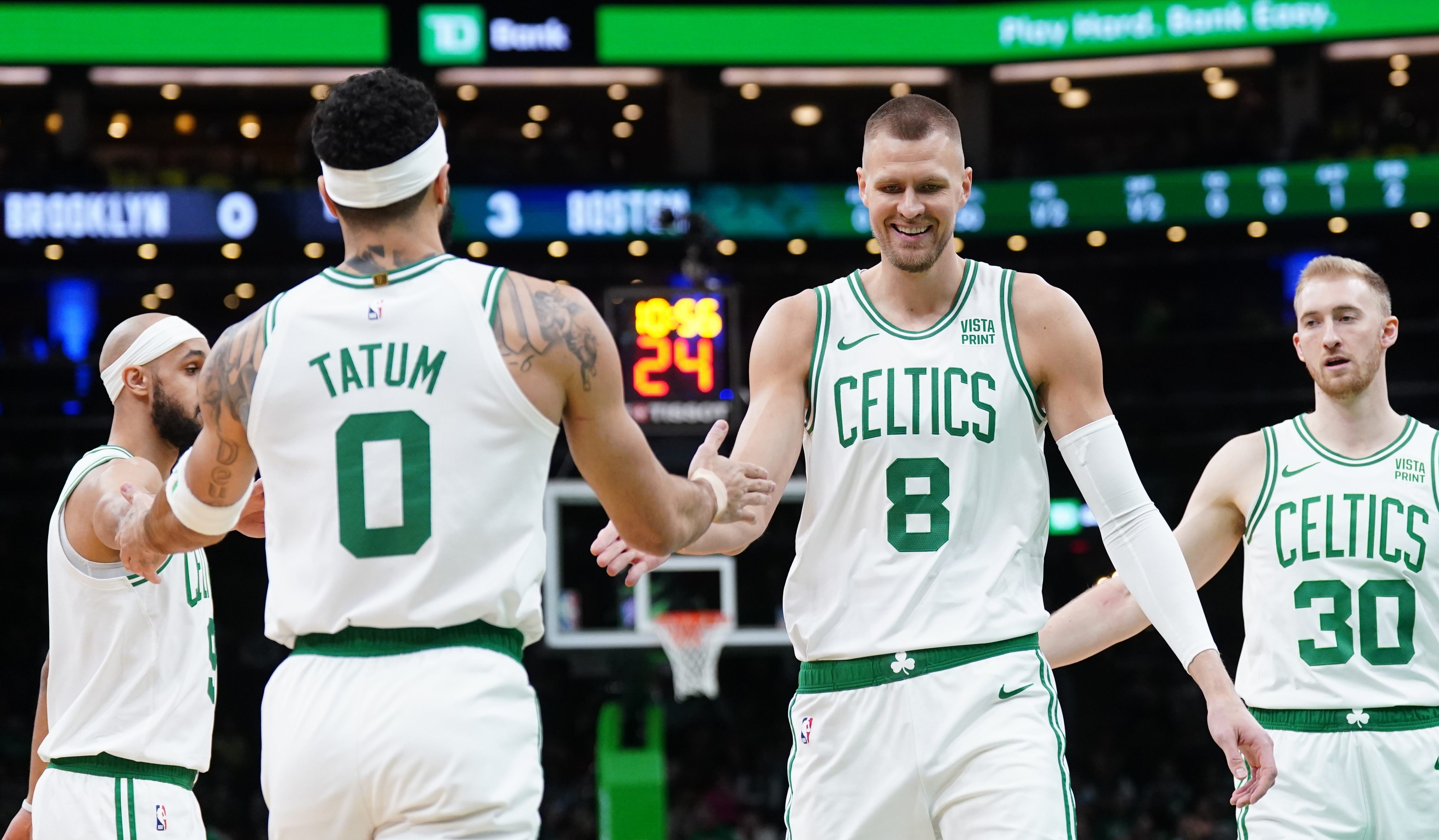 Feb 14, 2024; Boston, Massachusetts, USA; Boston Celtics center Kristaps Porzingis (8) and forward Jayson Tatum (0) react after a play against the Brooklyn Nets in the first half at TD Garden.
