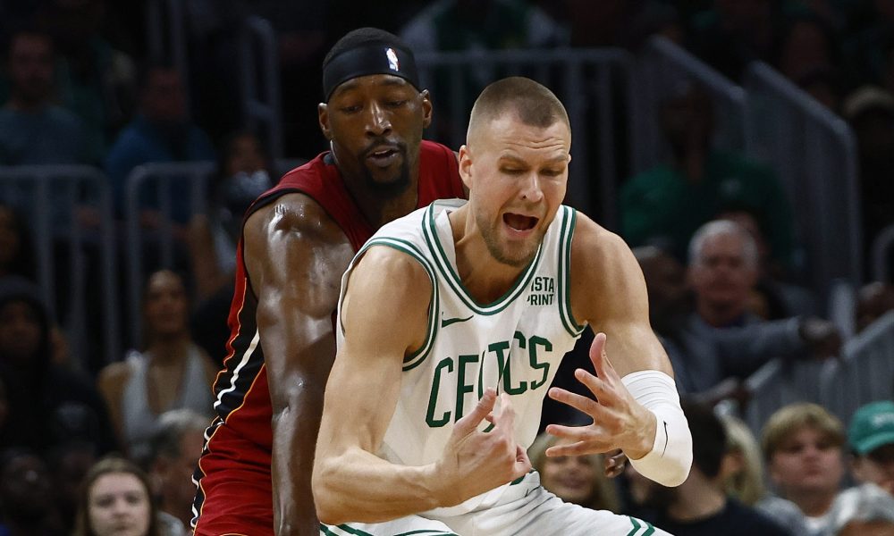 BOSTON, MA - APRIL 21: Bam Adebayo #13 of the Miami Heat knocks the ball away from Kristaps Porzingis #8 of the Boston Celtics during the first quarter of game one of the Eastern Conference First Round Playoffs at TD Garden on April 21, 2024 in Boston, Massachusetts.